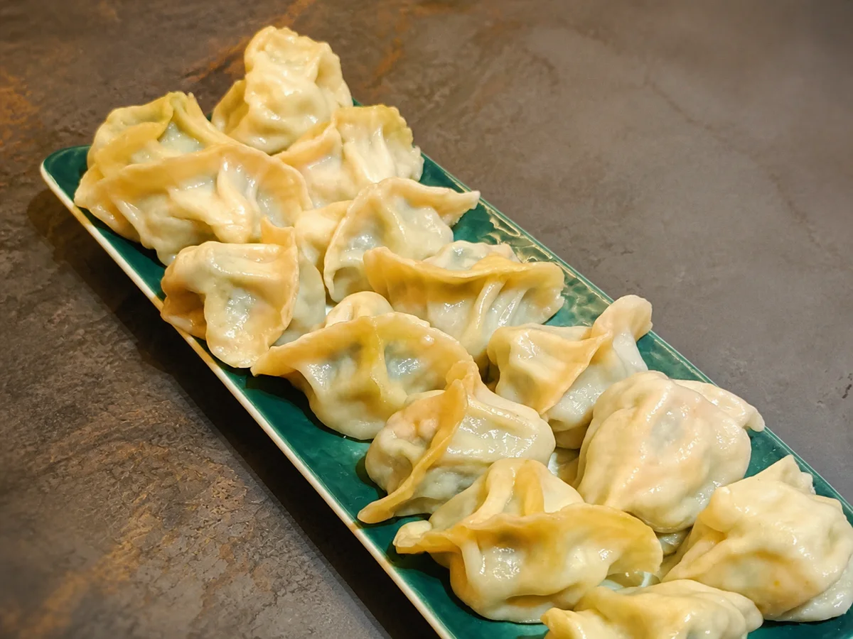 绿色餐盘上的蒸饺